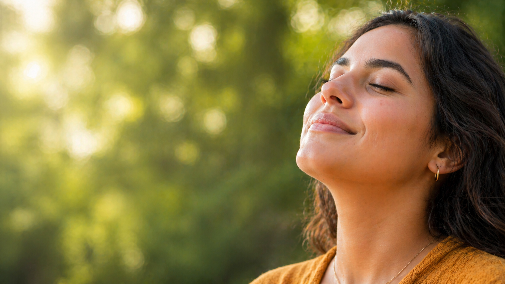 Mujer respirando con calma en un entorno natural como símbolo de bienestar emocional en Psicoplenitud